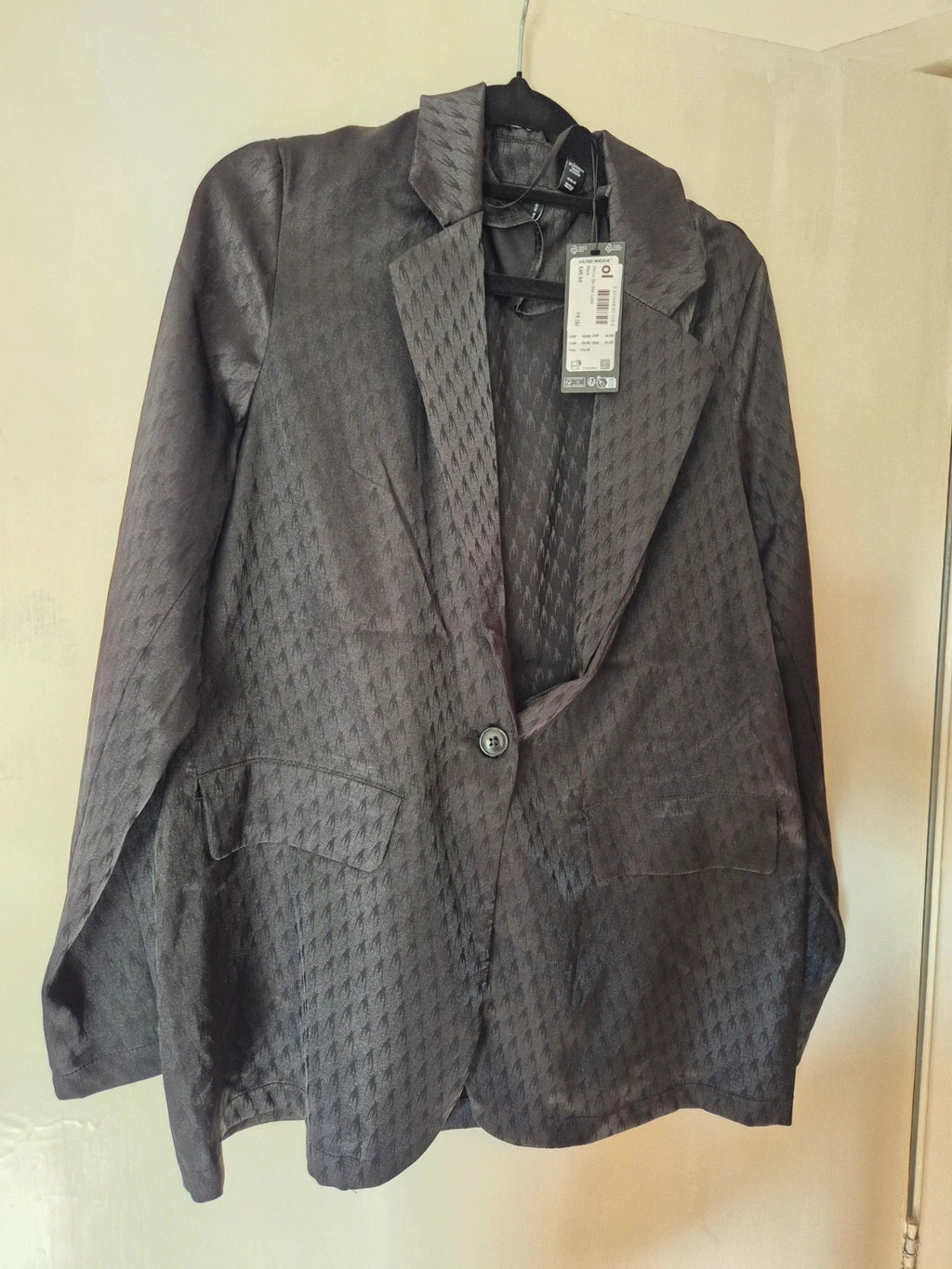 Amy Lynn black coat with satin sheen, ruched detailing, and plunge V-neckline.