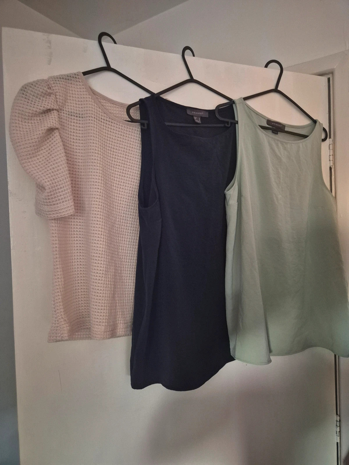 Primark multi vests bundle featuring cream waffle-knit, navy, and sage green tanks.