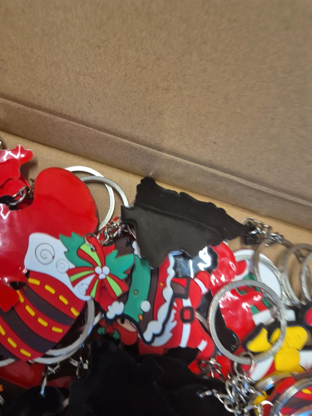 Accessories multi keychains in festive designs, packaged in three boxes.