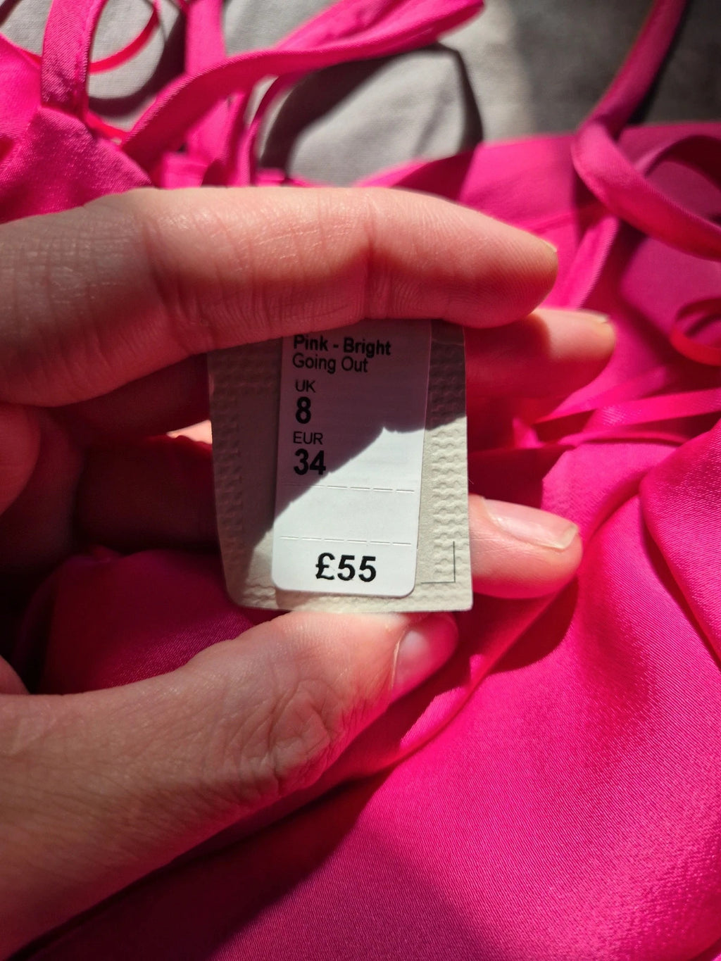 River Island pink bandage dress with structured design and tag attached.