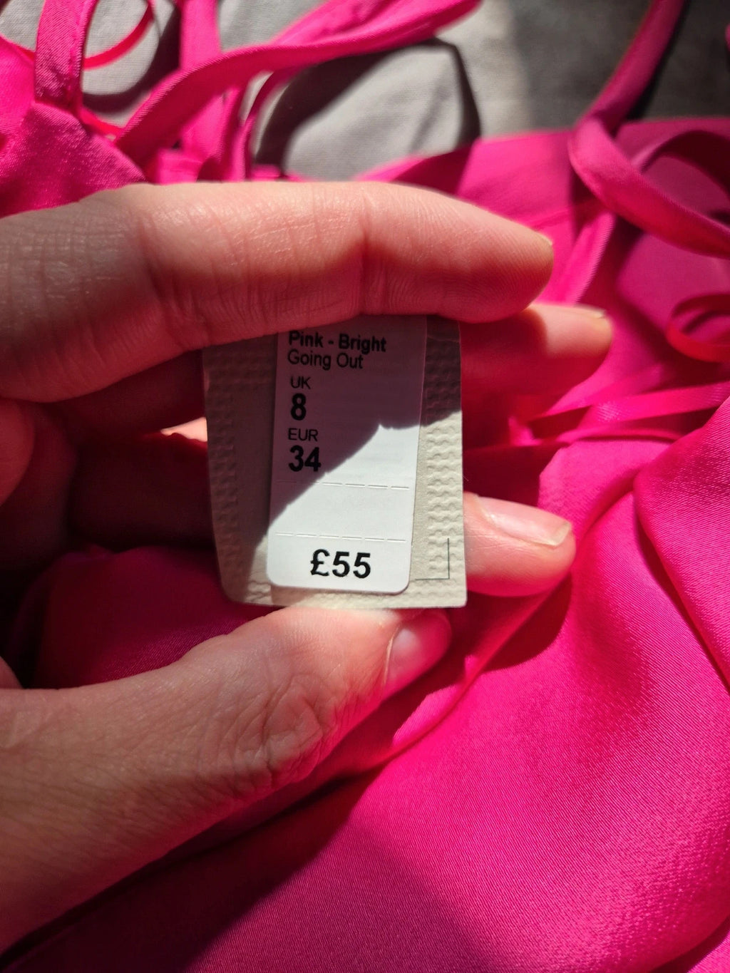 River Island pink bandage dress with structured design and tag attached.