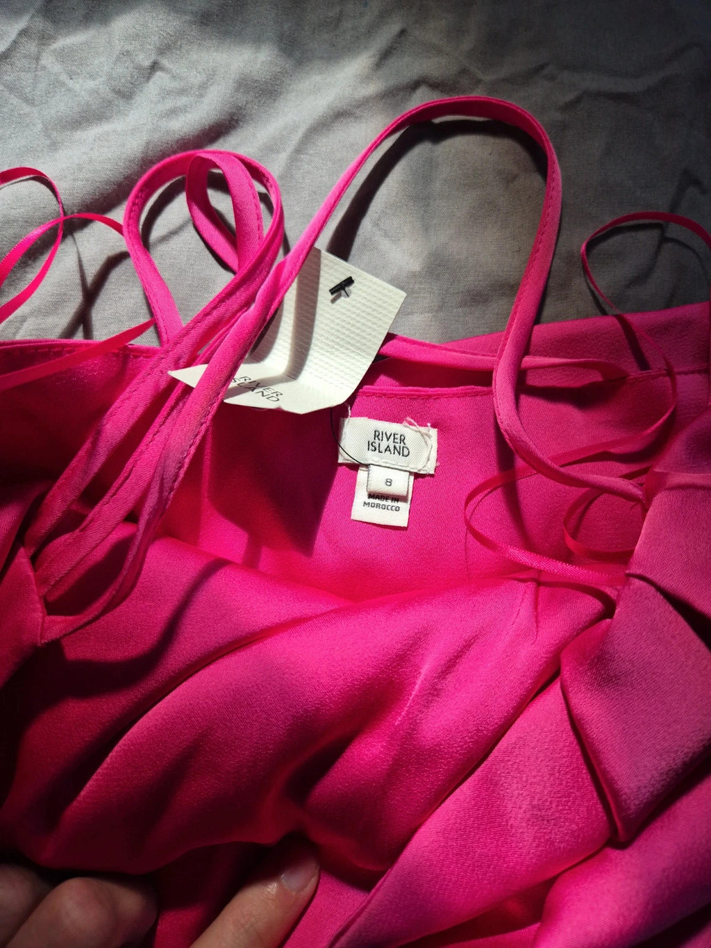River Island pink bandage dress with structured design and tag attached.