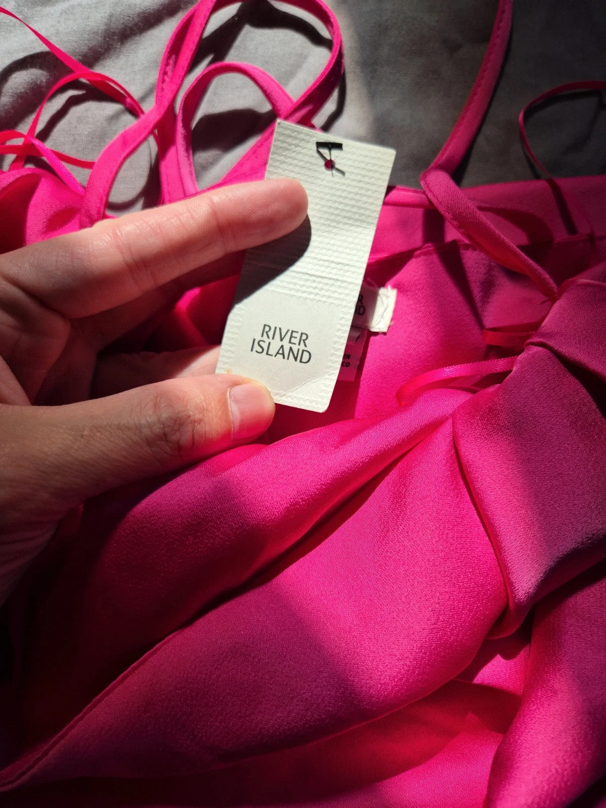 River Island pink bandage dress with structured design and tag attached.